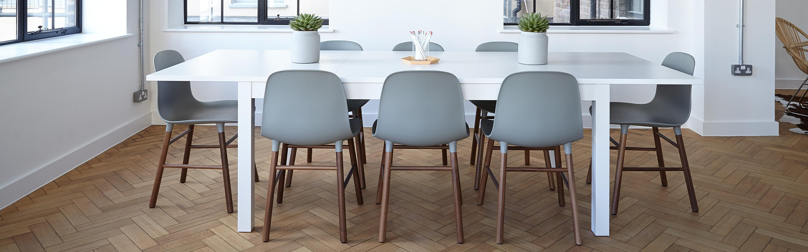 Commercial office space with a central meeting table and chairs, designed for collaboration and flexible use.