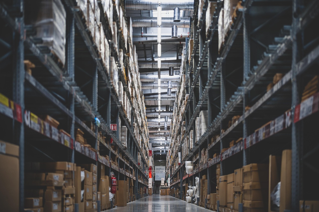 Warehouse interior with rows of shelves and boxes, to show the storage and logistical side of commercial operations.