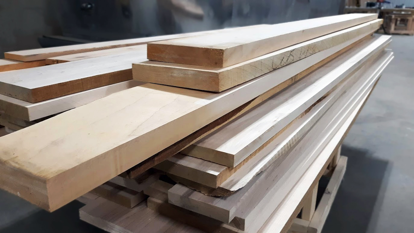 A stack of raw lumber, emphasizing the importance of sourcing high-quality materials to mitigate risks related to structural integrity and project delays in commercial construction.