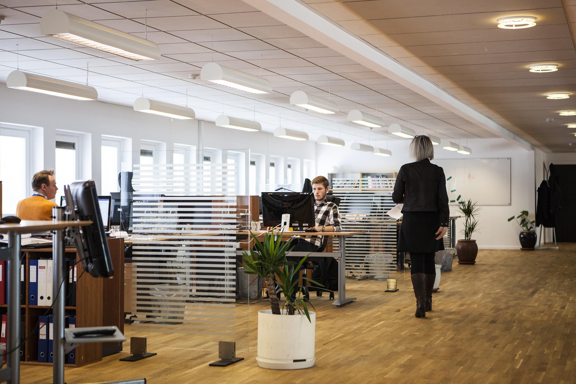 A bustling office full of potential and streamlined workflows. People are shown actively using the improved office space in a cohesive way.